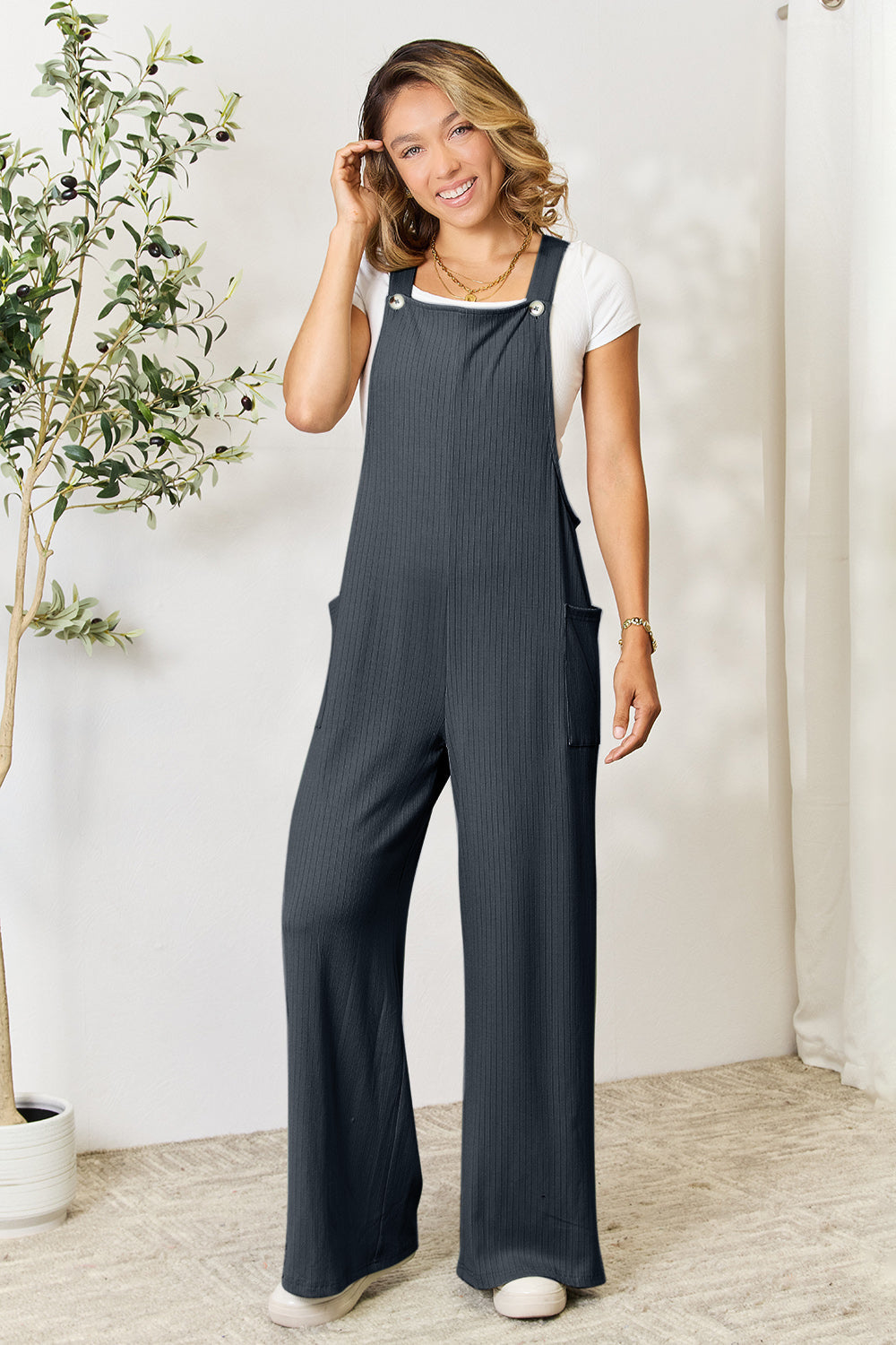 Woman wearing a wide strap overall with pockets made of polyester, rayon, and spandex, featuring a basic style and opaque fabric.