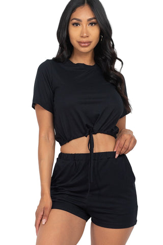 Woman wearing black front tied crop top and shorts set made of soft jersey fabric, perfect for casual summer wear.
