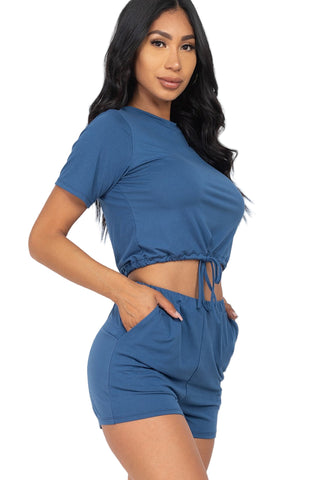 Woman wearing blue front tied crop top and shorts set made from soft Jersey fabric, perfect for casual summer wear.
