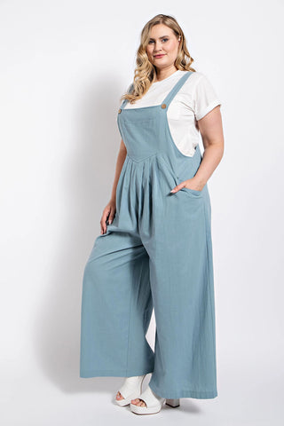 Woman wearing a blue pintuck detail overall with side pockets, showcasing casual elegance and comfortable cotton fabric.