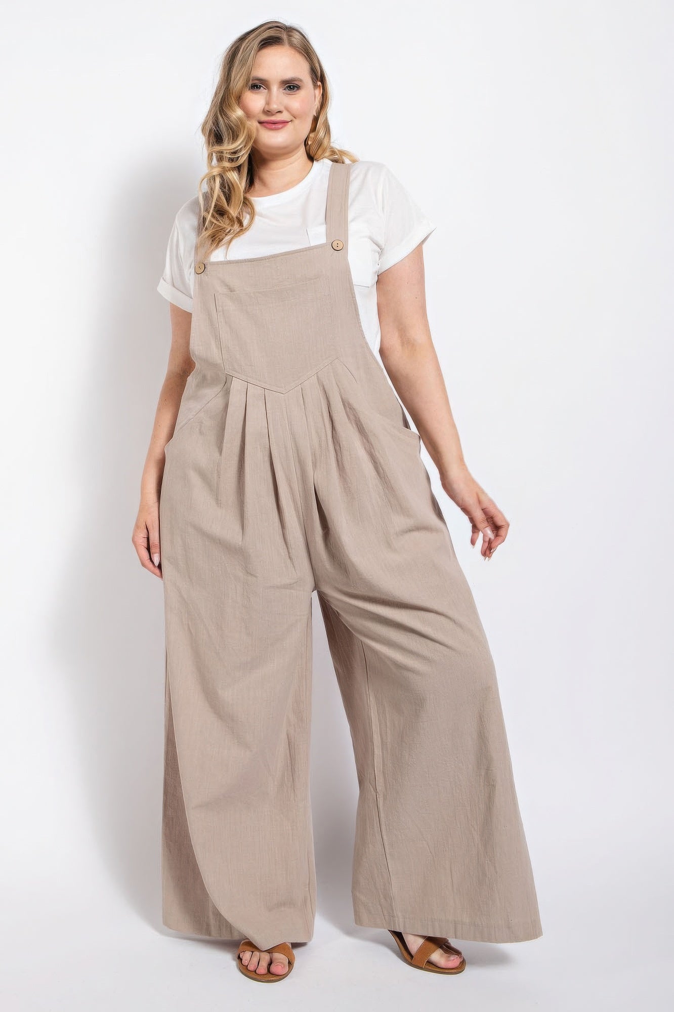Woman in stone-colored pintuck detail overall with side pockets, showcasing casual elegance in comfortable cotton fabric.
