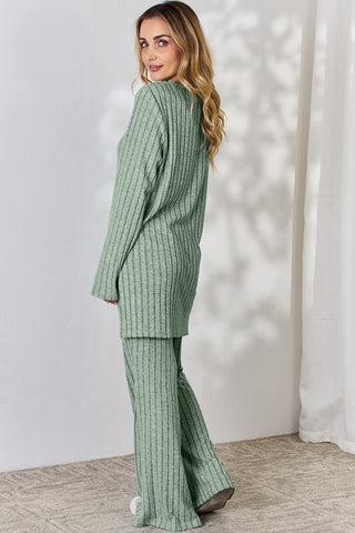 Woman wearing green ribbed high-low top and wide leg pants set, stylish two-piece with slightly stretchy material.