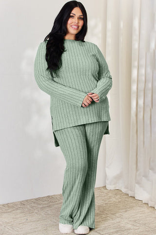 Curve model wearing green ribbed high-low top and wide-leg pants set, showcasing slightly stretchy material.