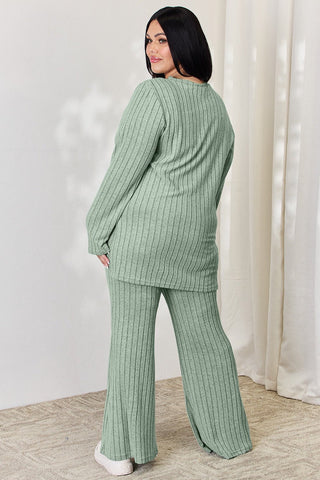 Woman in green ribbed high-low top and wide leg pants set, showing back view. Comfortable, stylish two-piece outfit.
