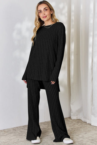 Woman wearing Basic Bae black ribbed high-low top and wide-leg pants set, showcasing a chic two-piece outfit.