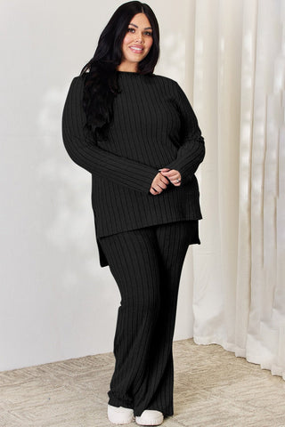 Plus-size model wearing black ribbed high-low top and wide-leg pants set, featuring a relaxed fit and cozy style.