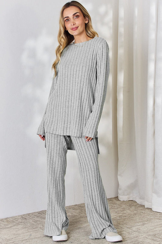 Woman wearing a gray ribbed high-low top and wide leg pants set, styled with sneakers, perfect for a casual look.