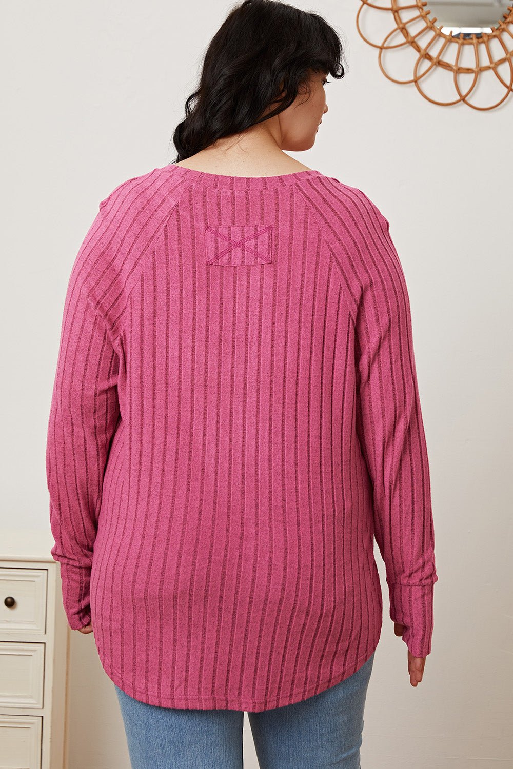 Woman wearing a pink Basic Bae full-size ribbed T-shirt with thumbhole sleeves, showcasing the back design.