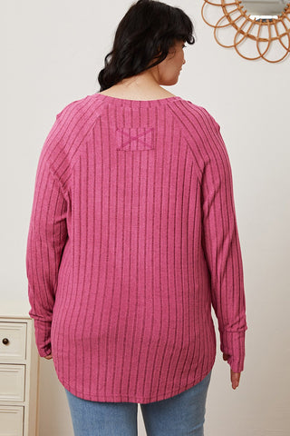 Woman wearing a pink Basic Bae full-size ribbed T-shirt with thumbhole sleeves, showcasing the back design.
