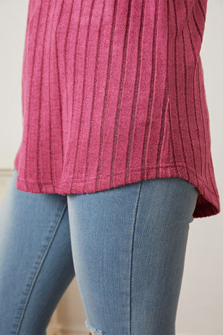 Ribbed pink t-shirt with thumbhole sleeves paired with blue jeans, showcasing a casual and stylish look.