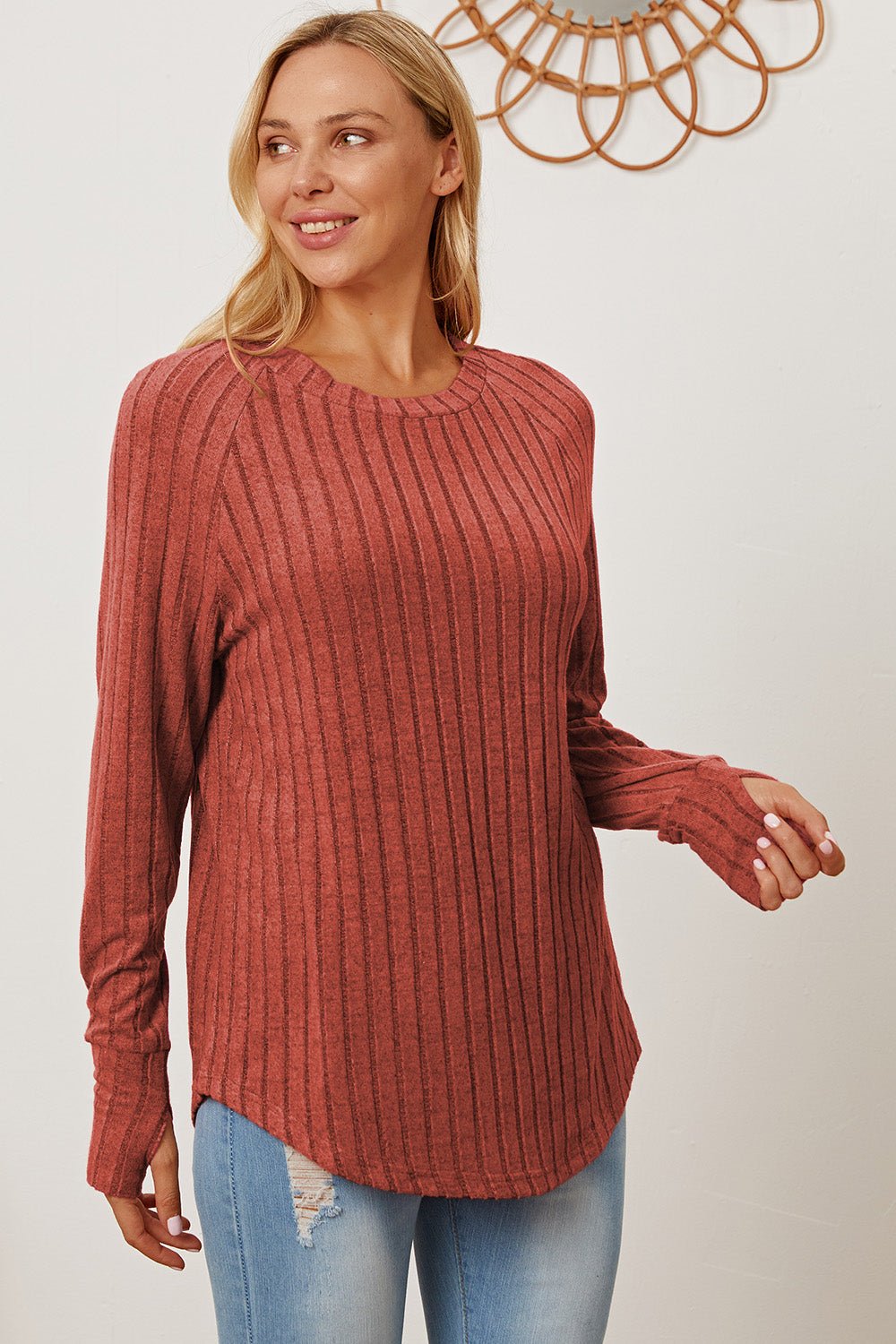 Woman wearing a red ribbed thumbhole sleeve t-shirt with jeans, showcasing the Basic Bae Full Size shirt's casual fit and stylish design.
