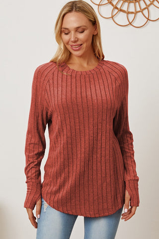 Woman wearing Basic Bae full-size ribbed thumbhole sleeve t-shirt in red, paired with denim jeans.