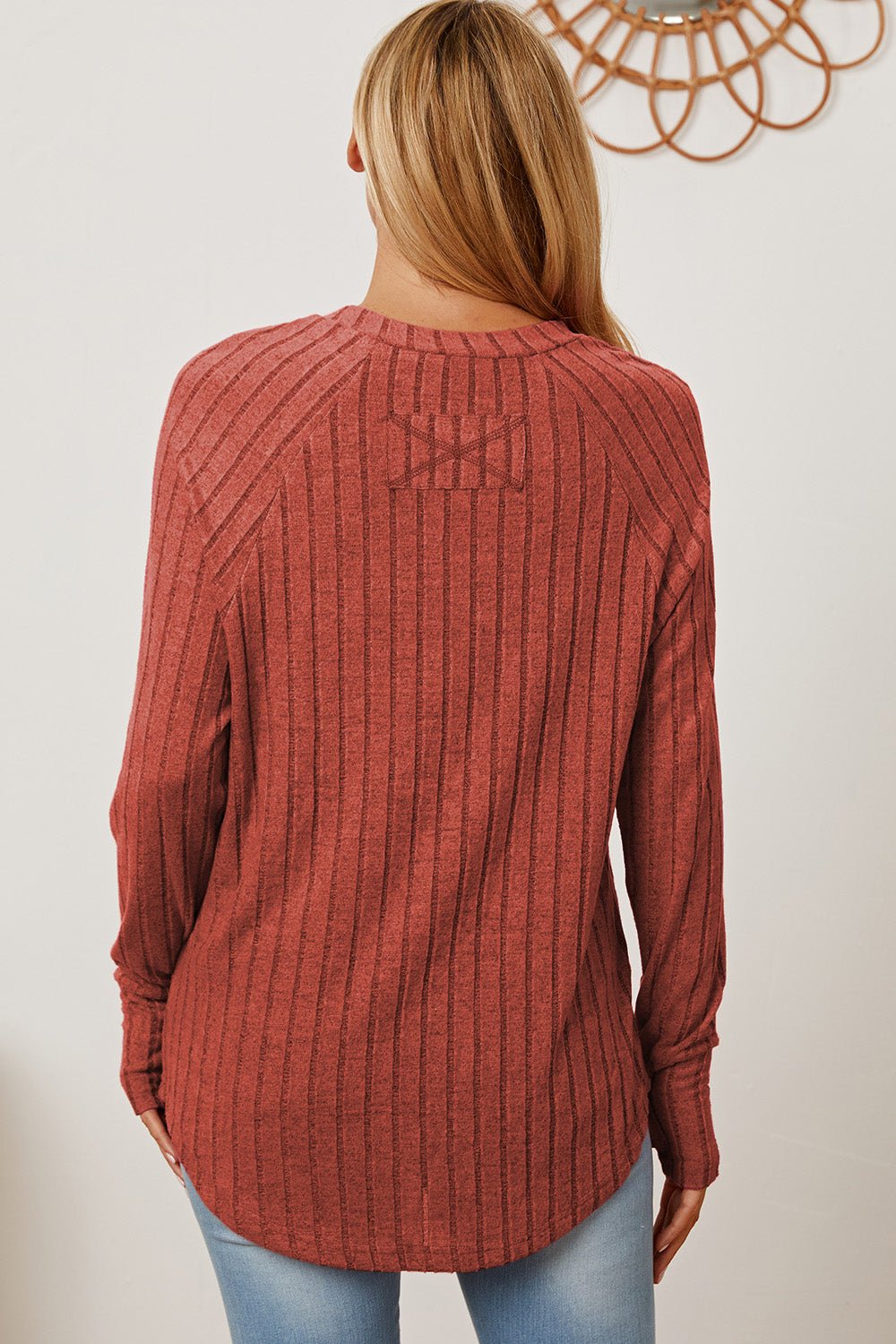 Woman wearing Basic Bae ribbed thumbhole sleeve t-shirt in red, showcasing back details with slightly stretchy fabric.