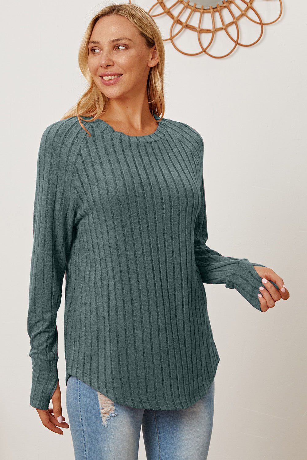 Woman wearing Basic Bae Full Size Ribbed Thumbhole Sleeve T-Shirt in teal with blue jeans, showcasing stylish casual wear.