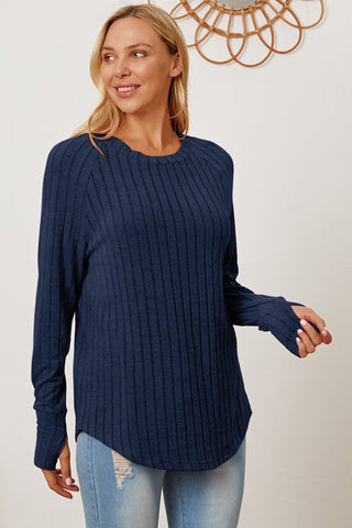 Woman wearing navy ribbed thumbhole sleeve t-shirt, styled casually with light denim jeans.