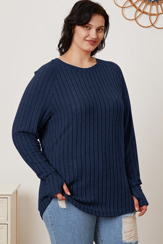 Woman wearing Basic Bae Full Size Ribbed Thumbhole Sleeve T-Shirt in navy blue, paired with ripped jeans, smiling confidently.