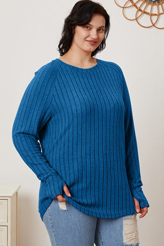 Woman wearing Basic Bae Full Size Ribbed Thumbhole Sleeve T-Shirt in blue, paired with distressed jeans.