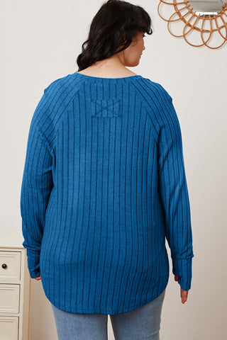 Woman wearing blue ribbed thumbhole sleeve t-shirt, back view showcasing textured fabric and relaxed fit.