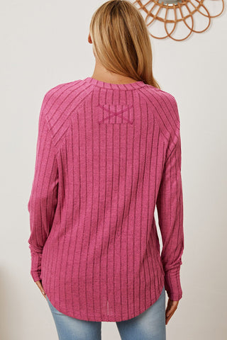 Woman wearing pink ribbed thumbhole sleeve t-shirt, back view showcasing design and fit