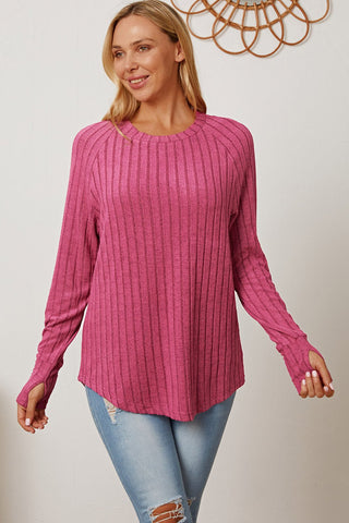 Pink ribbed thumbhole sleeve t-shirt styled with ripped jeans, featuring a casual and comfortable look.