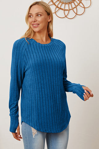Woman wearing blue ribbed thumbhole sleeve T-shirt with a casual look.