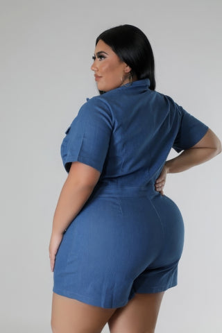 Woman wearing blue semi-stretch romper with collar and pockets, showing back view and short sleeves, in sizes 1XL to 3XL.