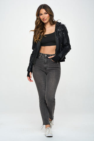 Woman wearing a black hooded long sleeve jacket with jeans and sneakers, showcasing a casual and stylish look.