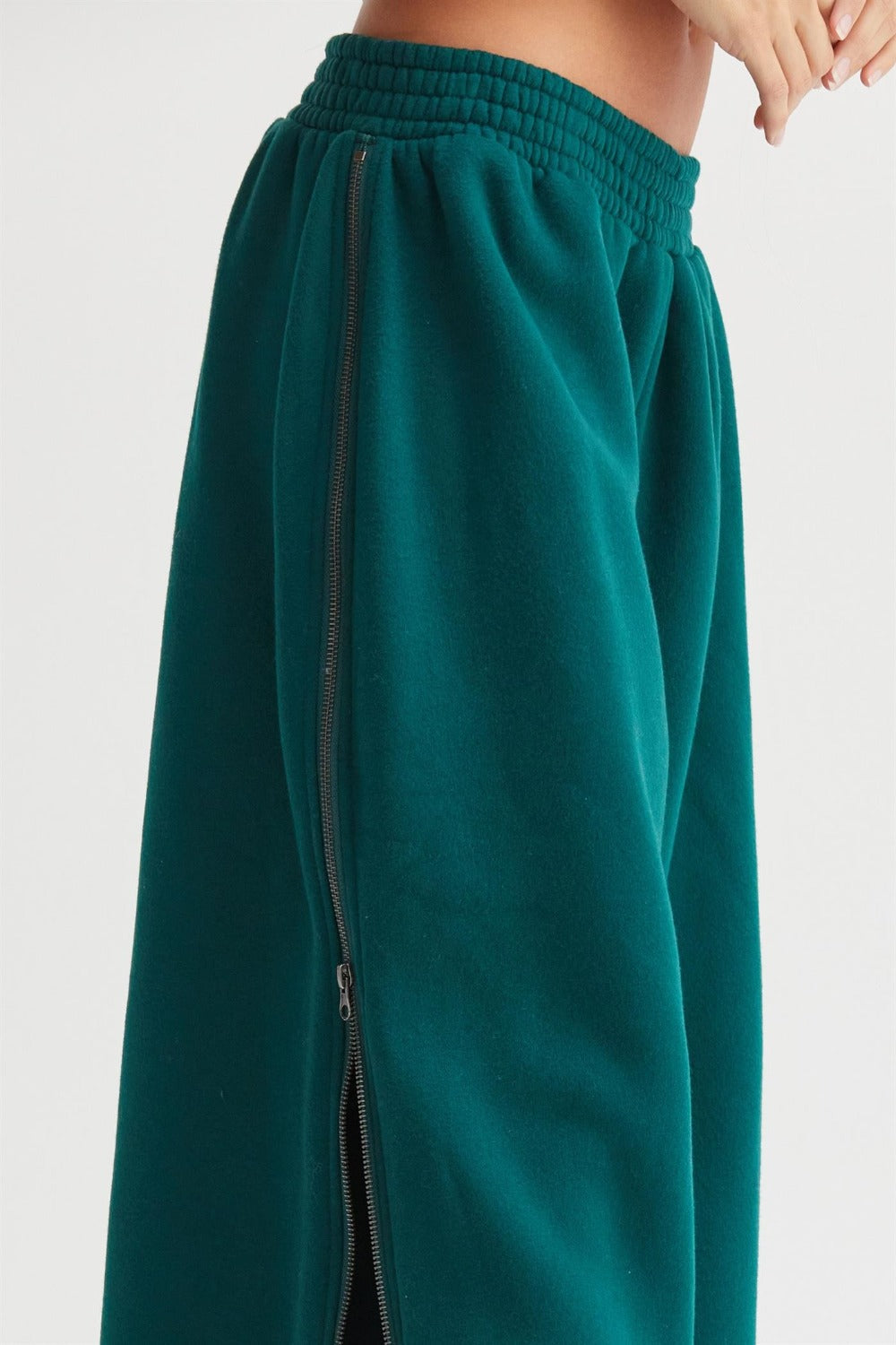 Women's dark green wide-leg sweatpants with side zipper, featuring an elastic waist and soft fabric for comfort and style.