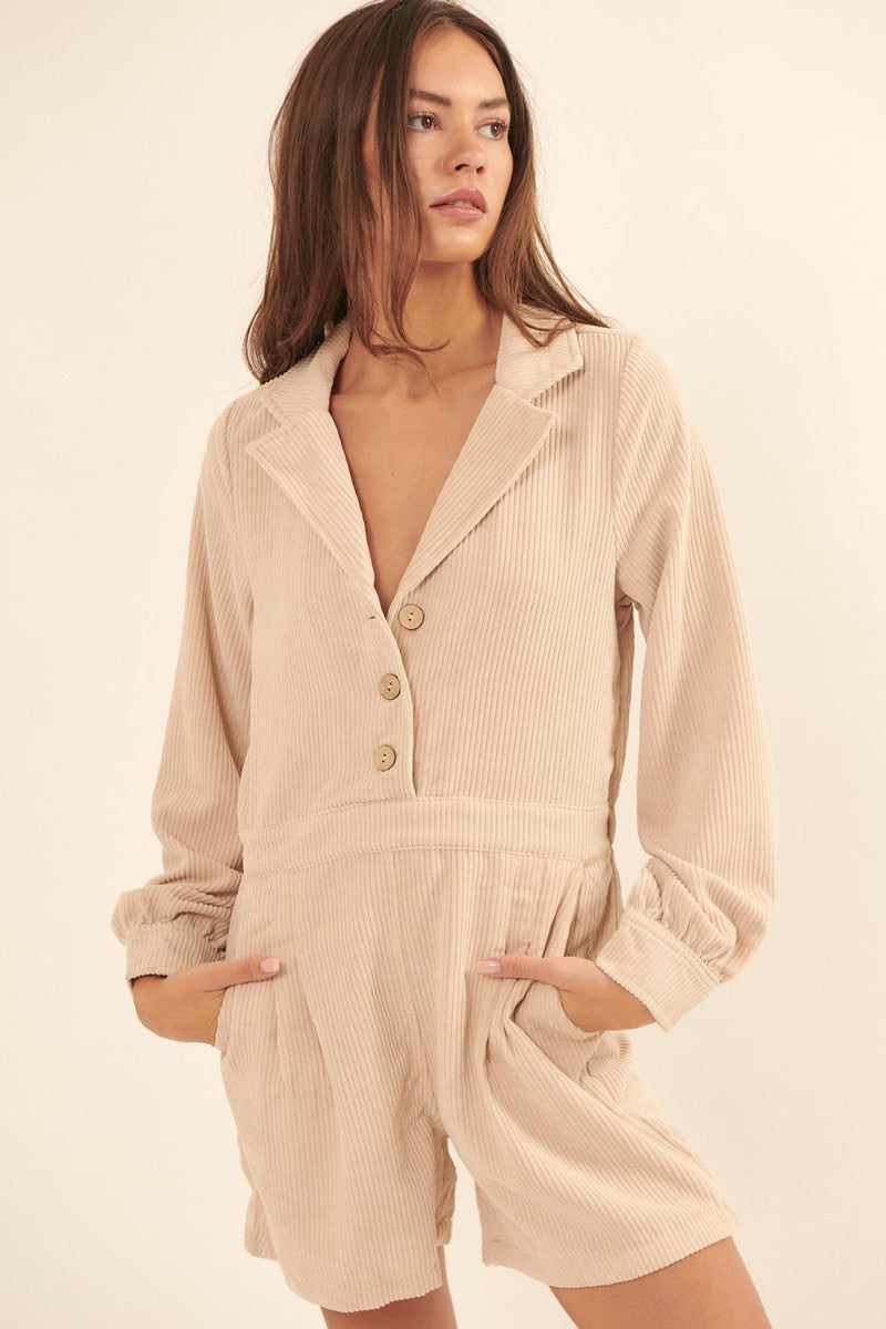 Cream woven corduroy romper with lapel collar, half button front, elastic waist, and side pockets, featuring a relaxed fit and wide legs.