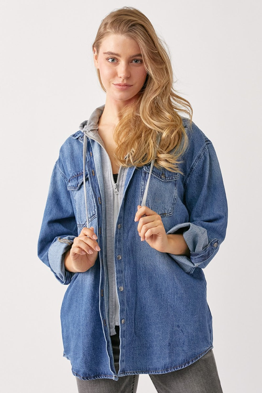 Woman wearing a zip-up hooded denim shirt with pockets and slightly stretchy 100% cotton material.